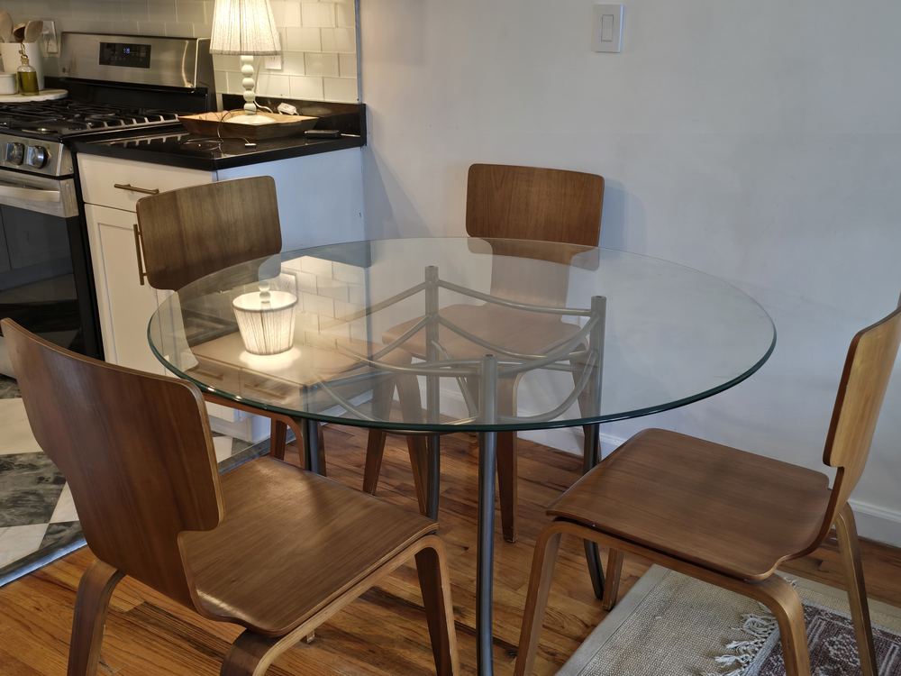 The hotel dining nook with a round glass table and chairs
