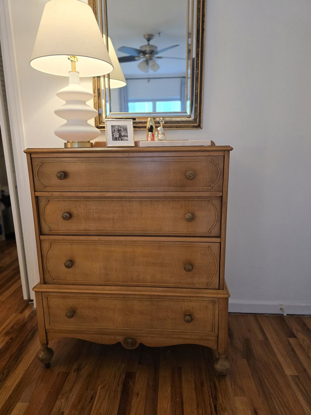 An elegant dresser with a mirror and lamp in the Royal Penthouse